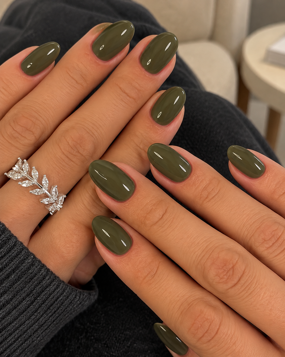 Short rounded nails painted muted moss green.