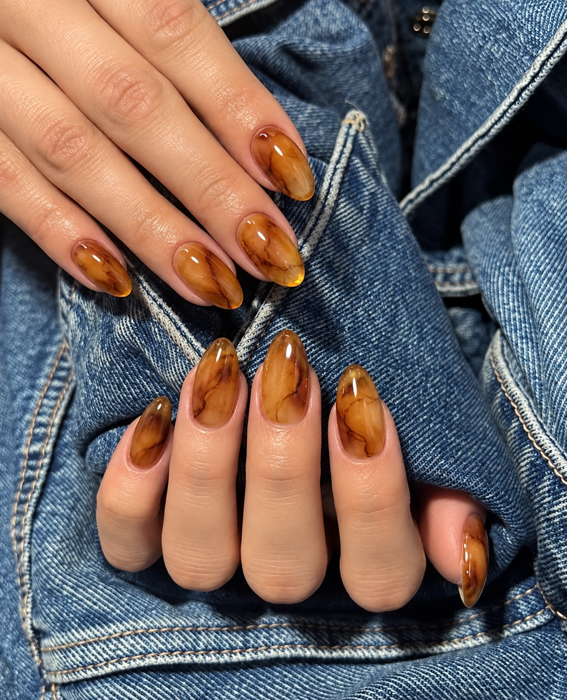 Translucent amber oval nails with fine smoky-brown stone-like veins.