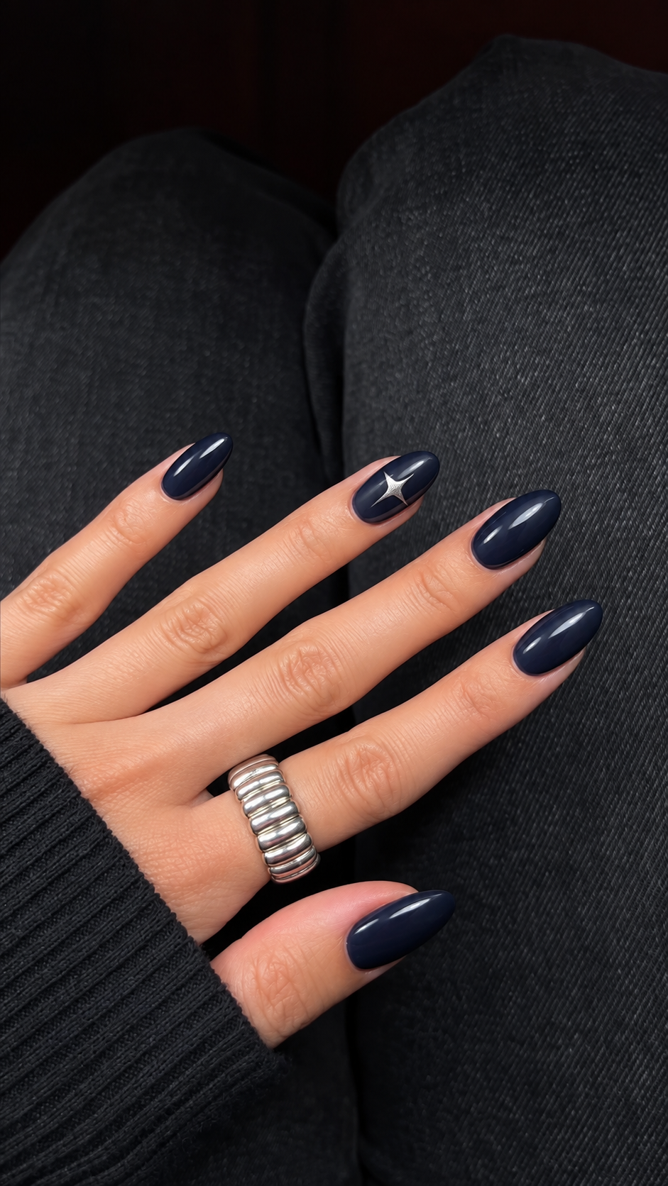 Smoky navy nails with one silver four-point star on the ring finger.