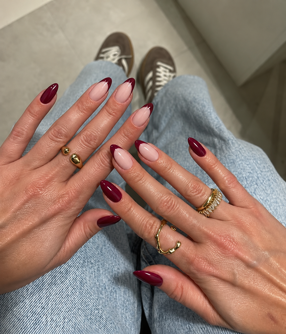 Almond nails combining cranberry French tips on the index and middle fingers with solid cranberry nails.