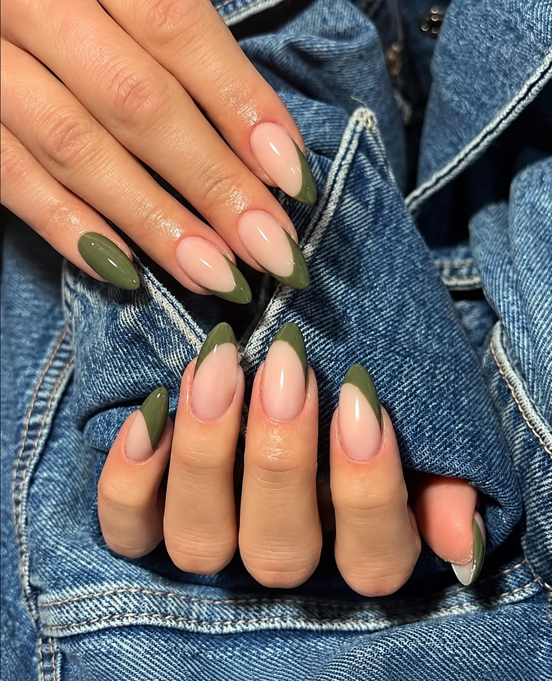 Oval nails with nude-beige bases and asymmetrical olive French tips sweeping along one side.