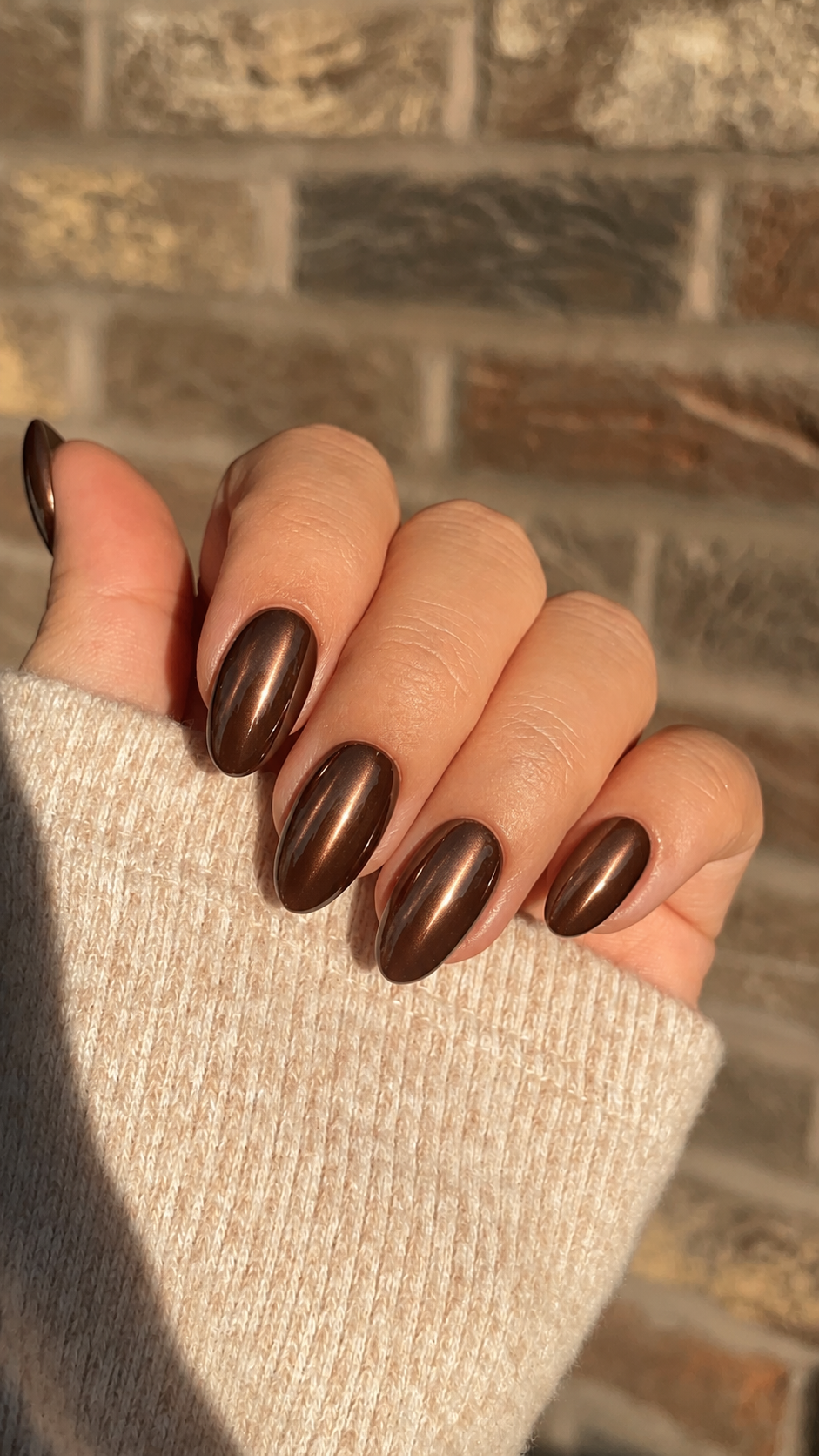 Oval nails with a smooth chocolate-brown chrome finish.