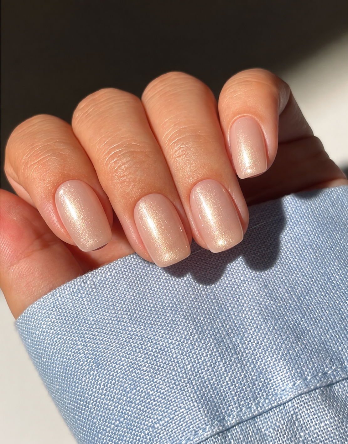 Short soft-square creamy nude nails with a subtle champagne pearl sheen.