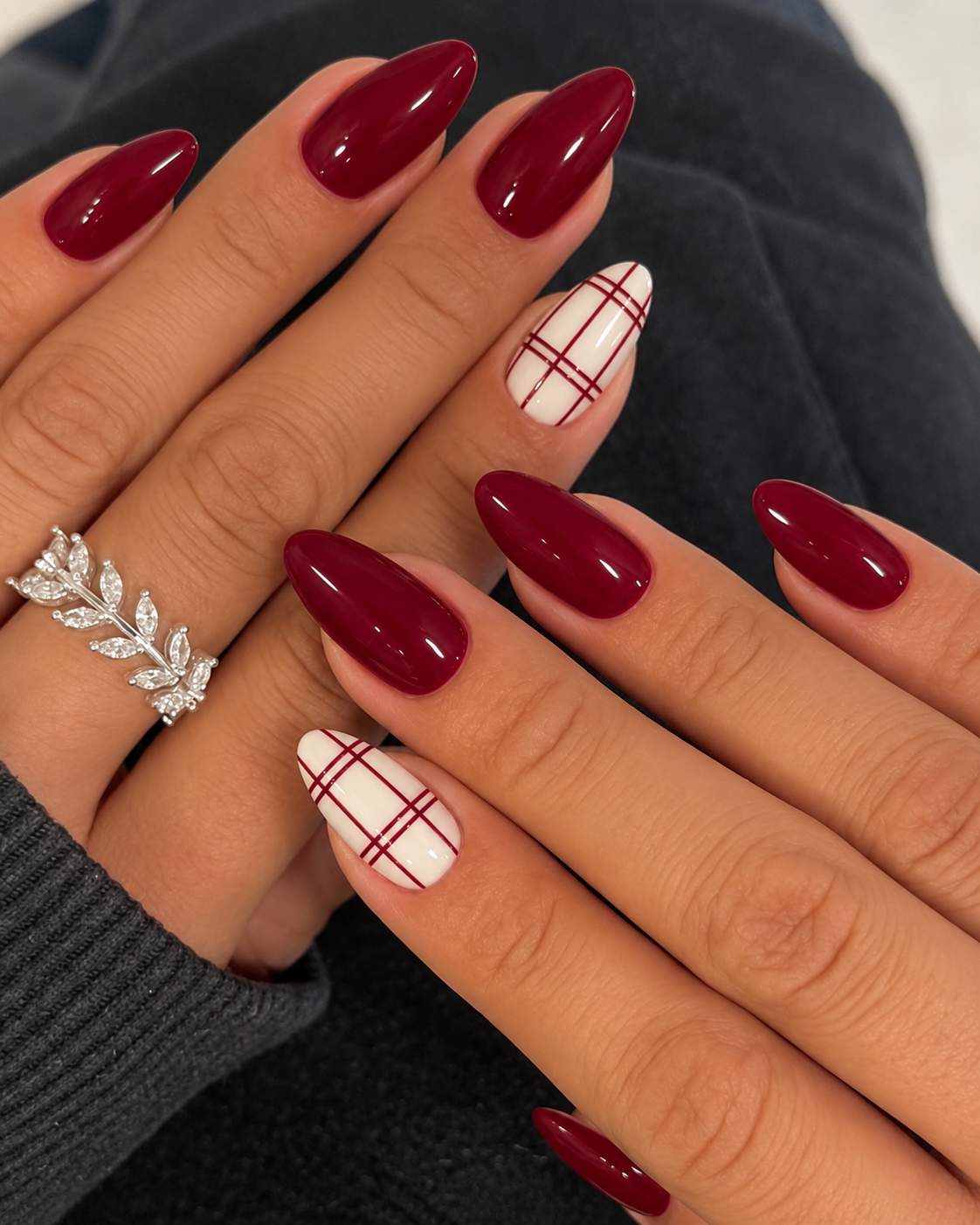 Cranberry nails with a cream ring-finger accent crossed by thin cranberry windowpane lines.