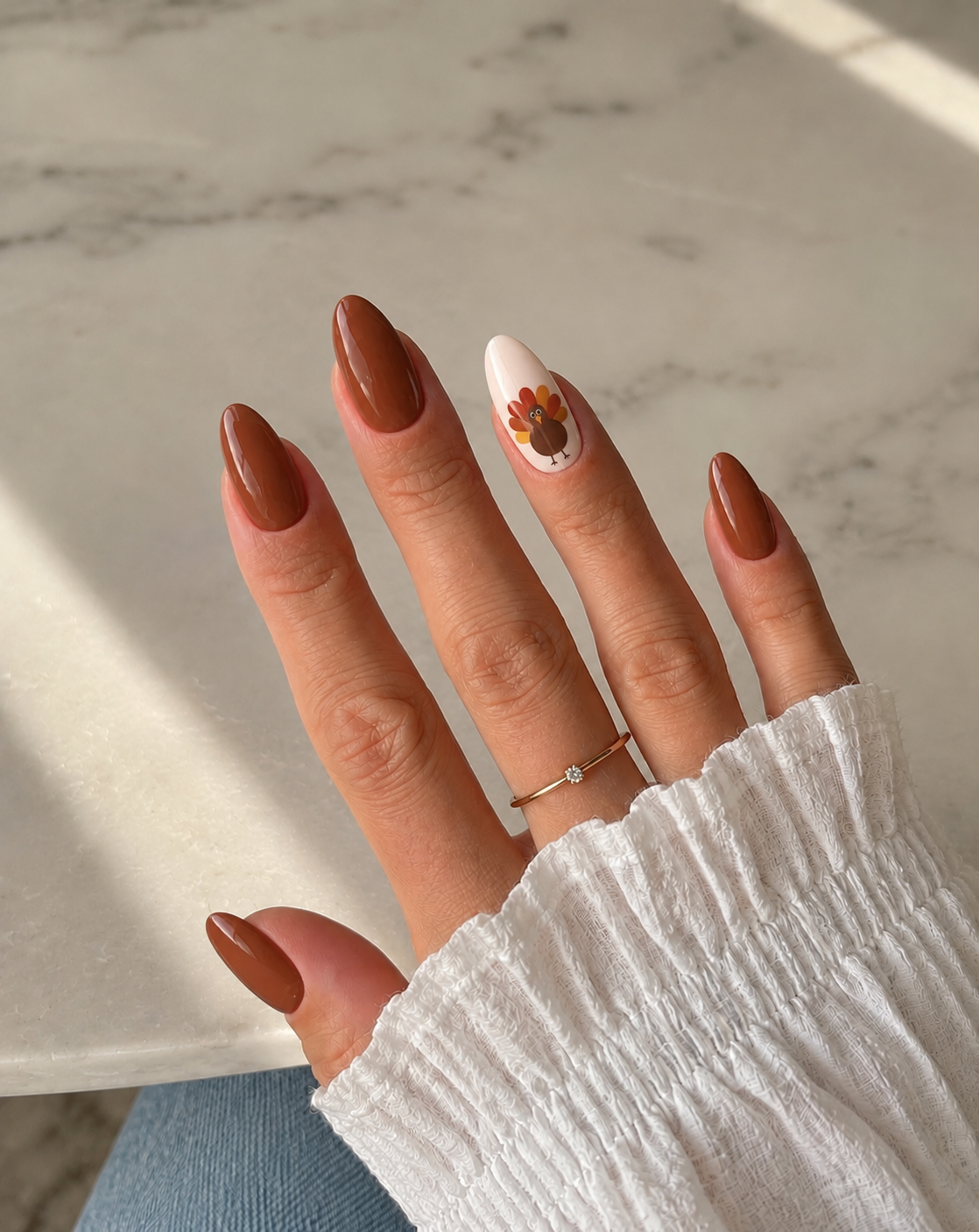 Chestnut nails with a small turkey painted on a cream ring-finger accent.